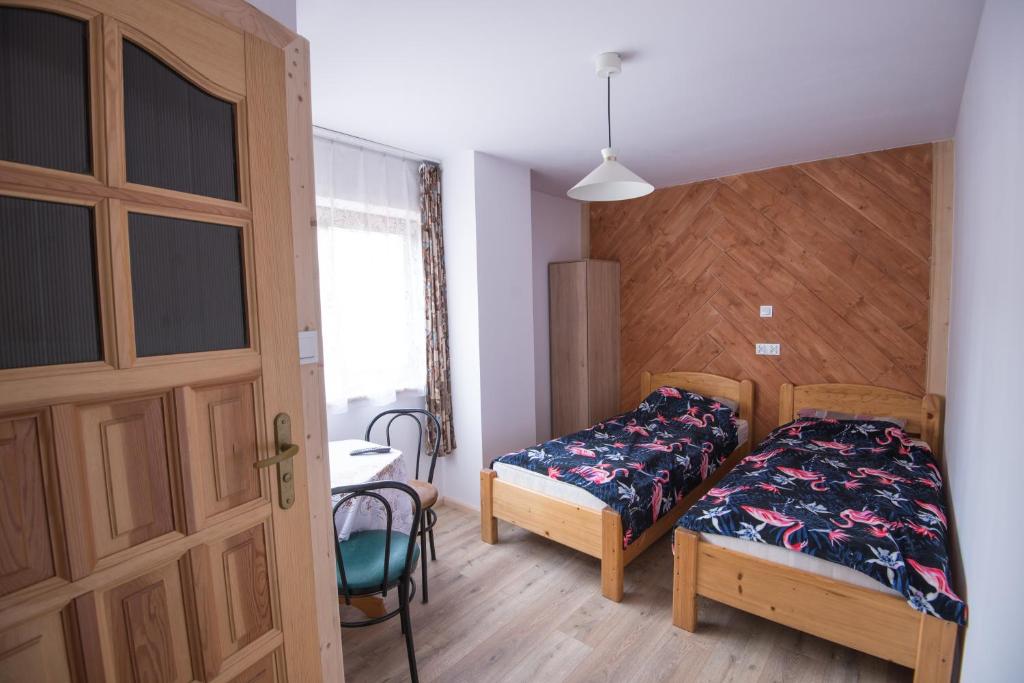 pokój z 2 łóżkami, stolikiem obiekt Willa Pod Jasieniami w mieście Białka Tatrzanska