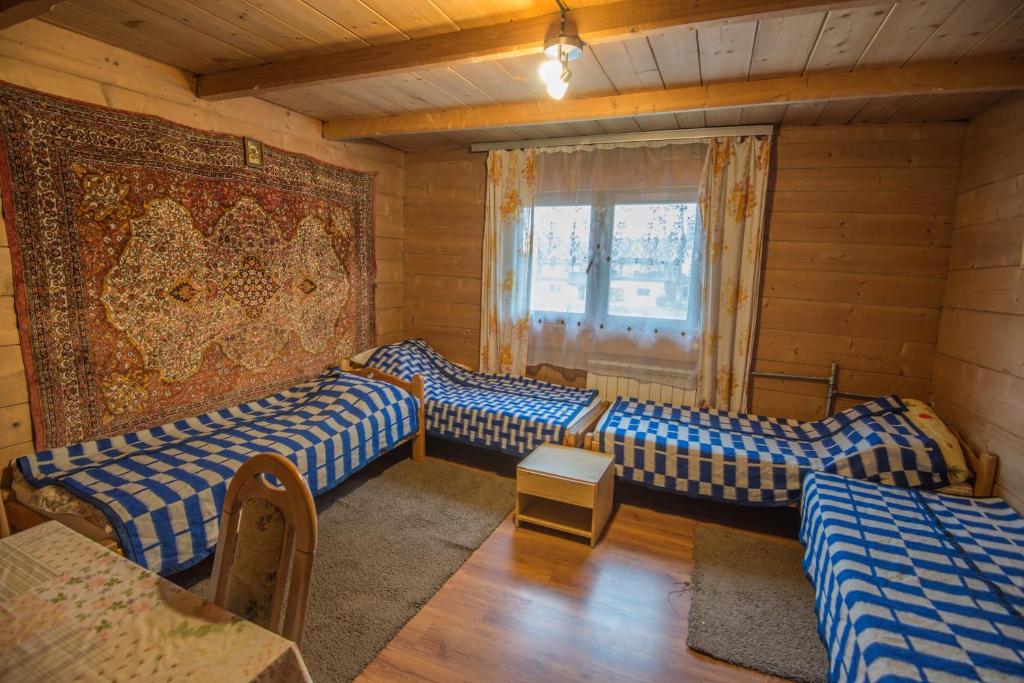 pokój z 4 łóżkami, stołem i krzesłem w obiekcie Pokoje u Cekusa w mieście Białka Tatrzanska