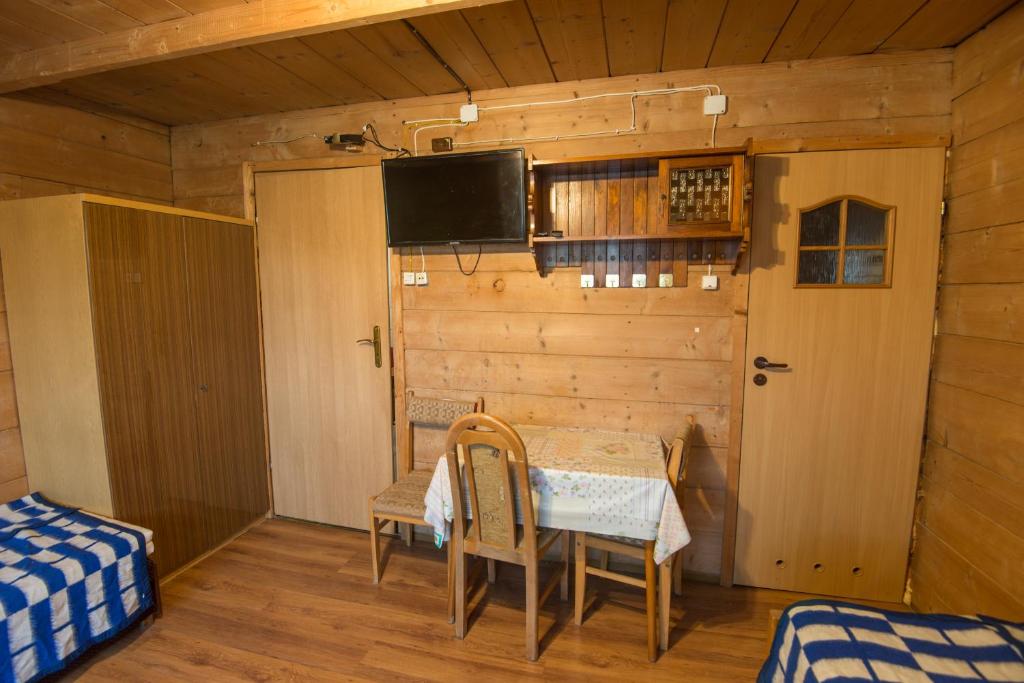 pokój z telewizorem, stołem i krzesłami w obiekcie Pokoje u Cekusa w mieście Białka Tatrzanska