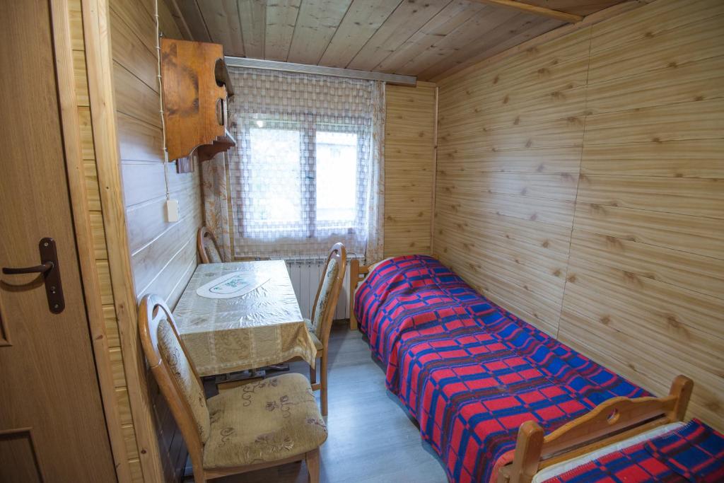 pokój z 2 łóżkami, stołem i krzesłami w obiekcie Pokoje u Cekusa w mieście Białka Tatrzanska