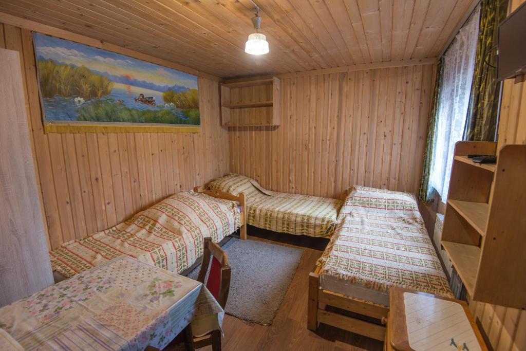 pokój z 3 łózkami, stałem i krzesłami w obiekcie Pokoje u Cekusa w mieście Białka Tatrzanska