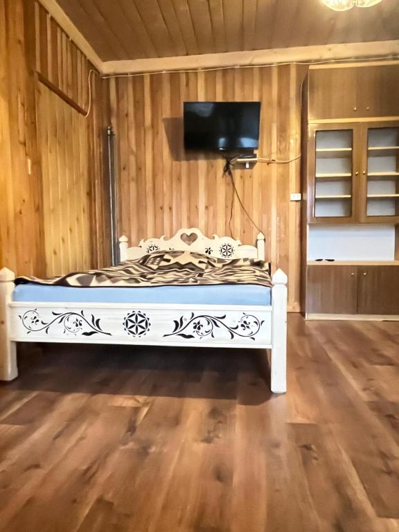 pokój z zdobionym łóżkiem i telewizorem w obiekcie Pokoje u Cekusa w mieście Białka Tatrzanska