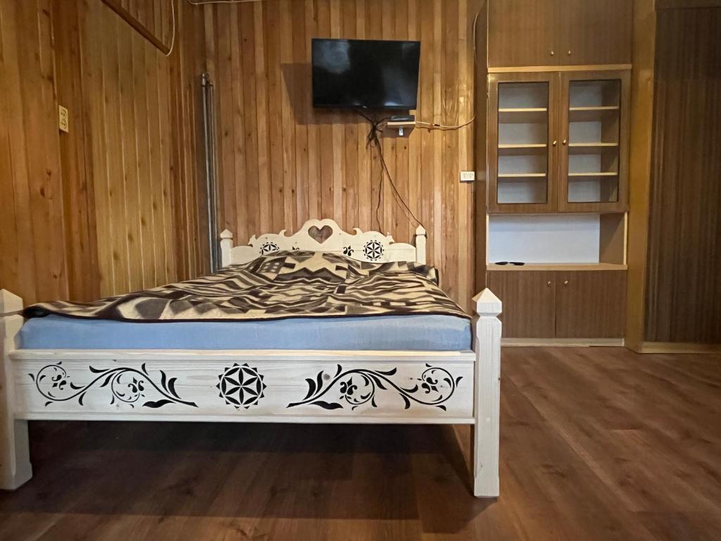 pokój z ozdobnym łóżkiem i telewizorem obiekt Pokoje u Cekusa w mieście Białka Tatrzanska