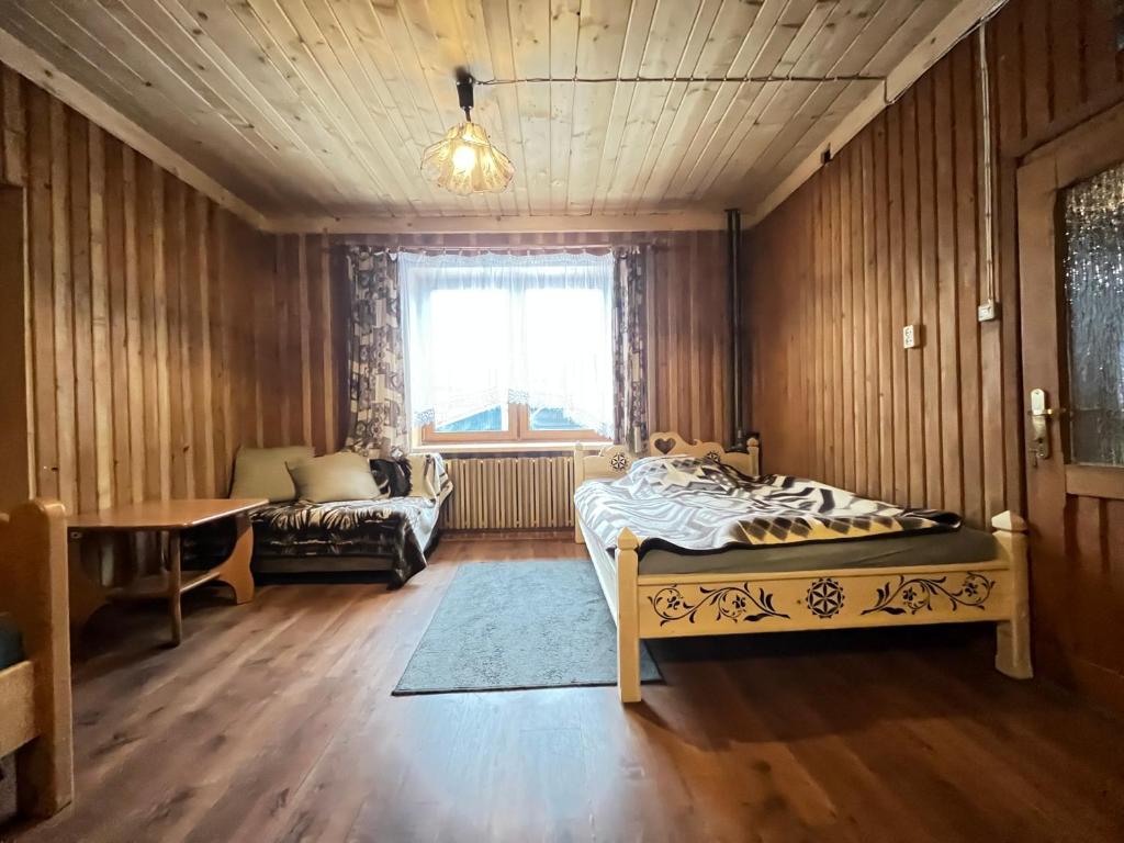 pokój z 3 łóżkami, stolikiem obiekt Pokoje u Cekusa w mieście Białka Tatrzanska