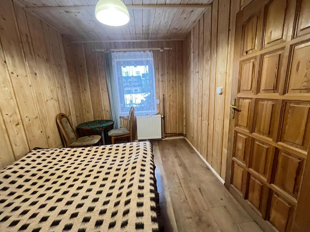 pokój z łóżkiem i stołem z krzesłami obiekt Pokoje u Cekusa w mieście Białka Tatrzanska