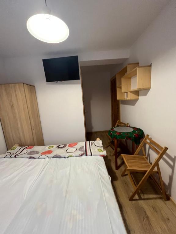 pokój z 2 łóżkami, telewizorem, szafą, stołem i krzesłami w obiekcie Willa Pod Jasieniami w mieście Białka Tatrzanska