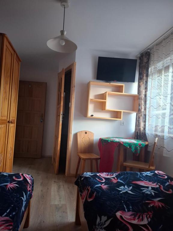 pokój z telewizorem i stolikiem z krzesłami obiekt Willa Pod Jasieniami w mieście Białka Tatrzanska