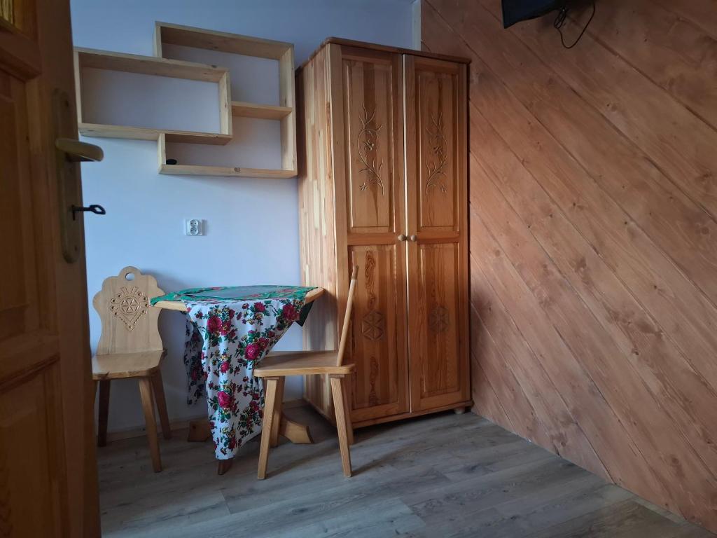 pokój szafą, stołem i krzesłami w obiekcie Willa Pod Jasieniami w mieście Białka Tatrzanska