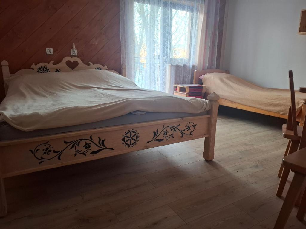 pokój z 2 łóżkami, jedno zdobione łóżko w obiekcie Willa Pod Jasieniami w mieście Białka Tatrzanska